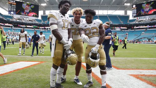 Georgia Tech linebacker Demetrius Knight II (17) defensive lineman Sylvain Yondjouen (32) and running back Jamious Griffin (22) pose as they celebrate after an NCAA college football game against Miami, Saturday, Oct. 19, 2019, in Miami Gardens, Fla. Georgia Tech defeated Miami 28-21 in overtime. (AP Photo/Wilfredo Lee)