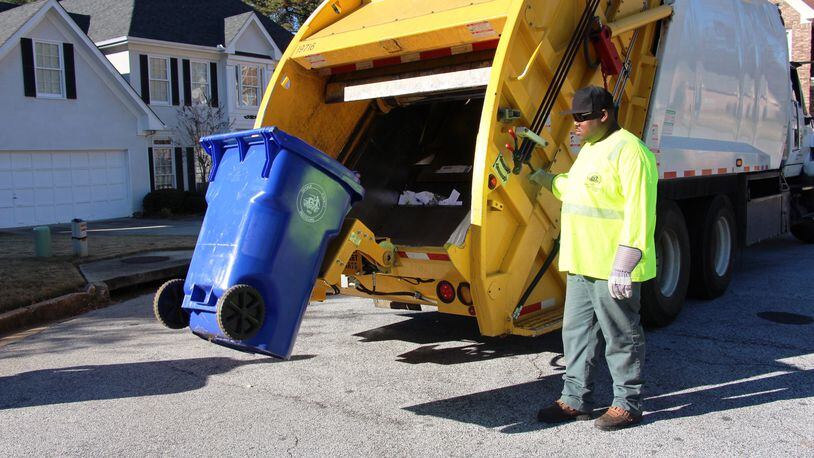 A DeKalb County sanitation worker empties a trash bin. SPECIAL PHOTO
