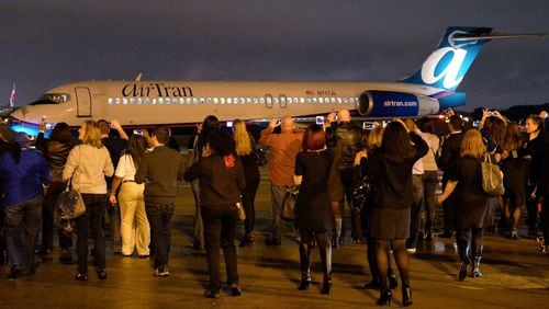 Employees take pictures as AirTran Flight 1 leaves the gate at Hartsfield-Jackson International for the final flight to Tampa. AirTran's operations have been absorbed by Southwest Airlines.