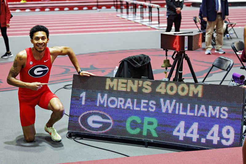 Georgia sophomore Christopher Morales Williams poses next to the scoreboard that recorded his world's-best 400-meter time of 44.79 seconds, which he ran Saturday, Feb. 24, 2024 at the SEC Indoor Track & Field Championships in Fayetteville, Arkansas. (Photo from UGA Athletics)
