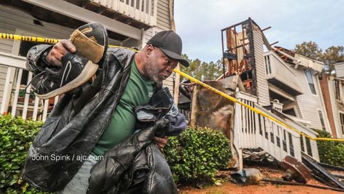 Stanley Anderson carries what few belongings he could salvage from his water-logged apartment Monday morning after fire ripped through one building in the Polo Club complex Sunday night.