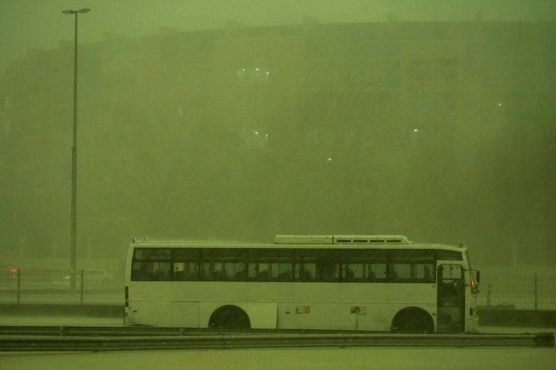 A bus stands abandoned in pouring rain as the sky turned green as a storm hit in Dubai, United Arab Emirates, Tuesday, April 16, 2024. Heavy rains lashed the United Arab Emirates on Tuesday, flooding out portions of major highways and leaving vehicles abandoned on roadways across Dubai. Meanwhile, the death toll in separate heavy flooding in neighboring Oman rose to 18 with others still missing as the sultanate prepared for the storm. (AP Photo/Jon Gambrell)