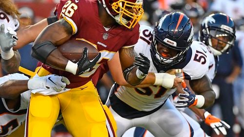Washington Redskins running back Adrian Peterson (26) carries the ball as Denver Broncos linebacker Todd Davis (51) defends during the first half at FedEx Field.