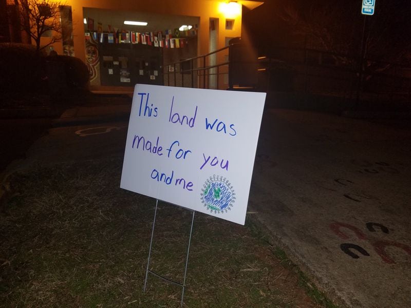 One of several dozen signs lining the entrance to the International Community School in Decatur late Sunday night.