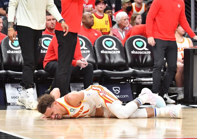 Hawks' guard Trae Young (11) reacts after falling to the court during the first half in an NBA basketball game at State Farm Arena on Thursday, March 31, 2022. (Hyosub Shin / Hyosub.Shin@ajc.com)