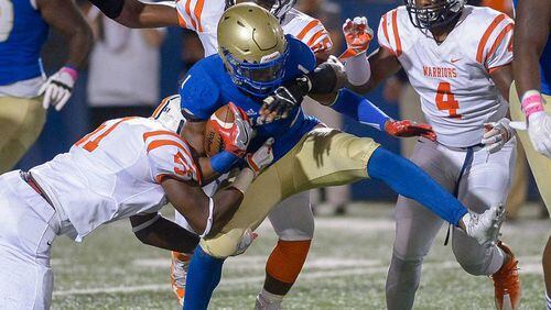 McEachern senior RB Quay Holmes (1) is brought down by North Cobb's Christian Albright (51), Michael Dixon (60) and Jai Erwin (4) in the first half of Friday's game. Daniel Varnado/Special