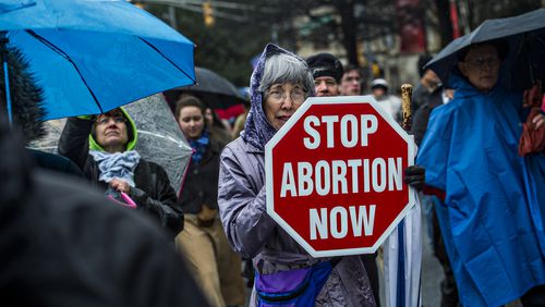 Janice McFarland (center) holds a pro life sign during the Georgia March for Life in Atlanta in January. Jonathan Phillips / For the AJC