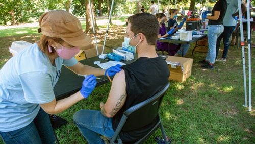 Emory University Physician Assistant student Nicole Groff gives Gage Kirby his vaccination shot during the Atlanta Jazz Festival in Piedmont Park on Sunday, September 5, 2021. The vaccinations were coordinated by Emory’s outbreak response team. STEVE SCHAEFER FOR THE ATLANTA JOURNAL-CONSTITUTION