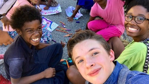 Aidan Anderson takes a selfie with kids at Adopt-a-Block, one of the causes to which the 16-year-old gives his time. CONTRIBUTED BY TOREN ANDERSON
