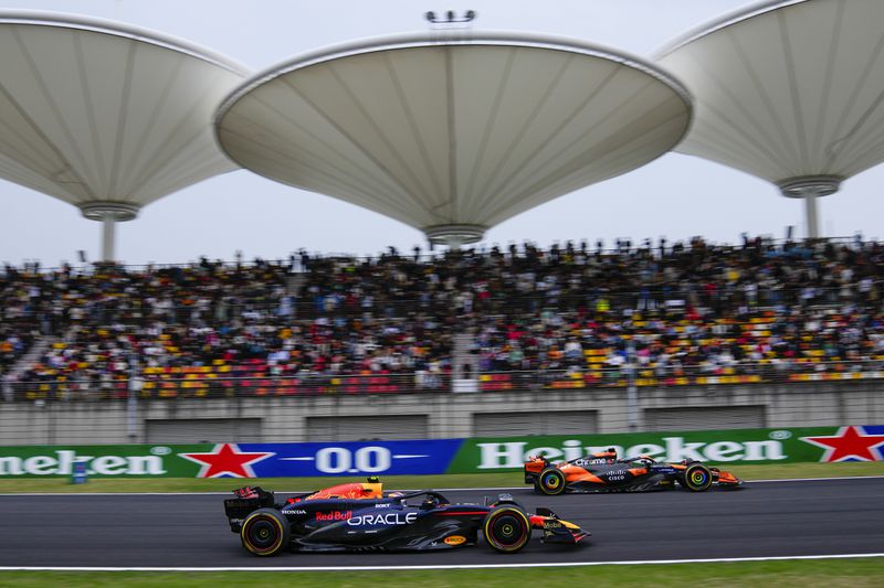 Red Bull driver Sergio Perez, left, of Mexico and McLaren driver Oscar Piastri of Australia steer their cars during the sprint qualifying session for the Chinese Formula One Grand Prix at the Shanghai International Circuit, Shanghai, China, Friday, April 19, 2024. (AP Photo/Andy Wong)