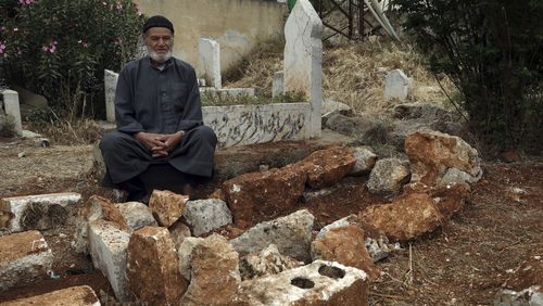FILE - Mohammed Hassan Masto sits next to the grave of his brother Lutfi on May 7, 2023, in the village of Qorqanya, a rural area in northern Idlib province, Syria. Central Command said Thursday, May 2, 2024, an airstrike in Syria that was targeting an al-Qaida leader misidentified the intended target and killed Lutfi Hassan Masto instead. The investigation confirms early reports from residents and family members shortly after the attack. (AP Photo/Omar Albam, File)