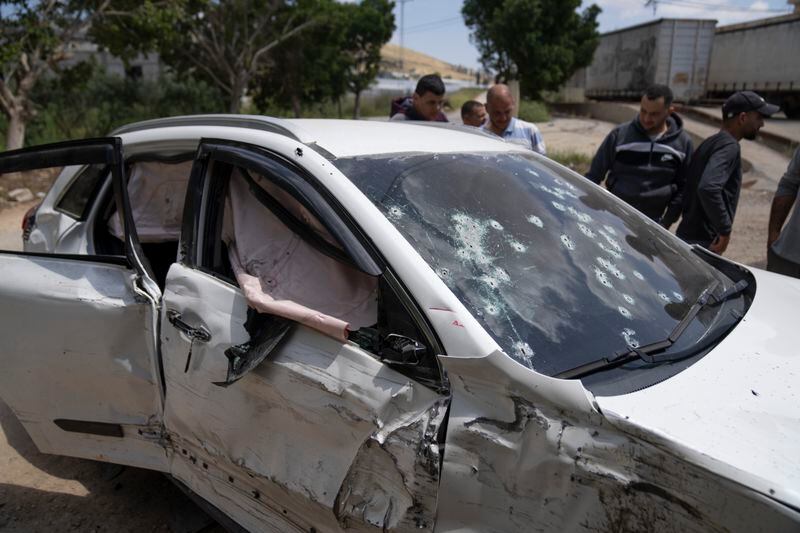 Palestinians inspect the shattered vehicle of Mohammad Daraghmeh, 26, a local Hamas commander who was killed in a shootout with Israeli soldiers early morning during an army raid, in the West Bank village of Tamoun, Friday, April 12, 2024. Two Palestinians were killed early Friday in confrontations with Israeli forces in the Israeli-occupied West Bank, Palestinian medics and the Israeli military said. The Islamic militant group Hamas said one of those killed was a local commander. (AP Photo/Nasser Nasser)