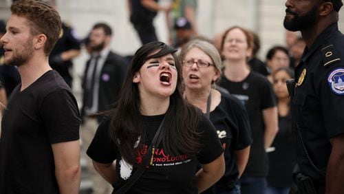 Protesters shout, sing and chant after being arrested by U.S. Capitol Police for demonstrating against the confirmation of Supreme Court nominee Judge Brett Kavanaugh on the center steps of the East Front of the U.S. Capitol on Oct. 06, 2018 in Washington, DC. (Photo by Chip Somodevilla/Getty Images)