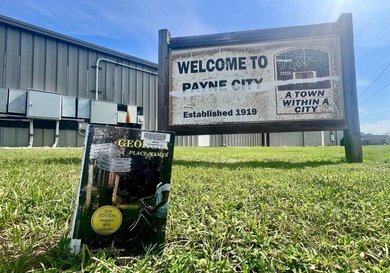 A copy of Kenneth Krakow’s “Georgia Place-Names,” first published in the 1970s, propped for this photo near a Payne City sign in Macon. According to the book, “William Sims Payne started Payne Mill and it was chartered February 25, 1876. The mill was sold to Bibb Manufacturing Co. in 1905.” (Photo Courtesy of Jason Vorhees/The Telegraph)