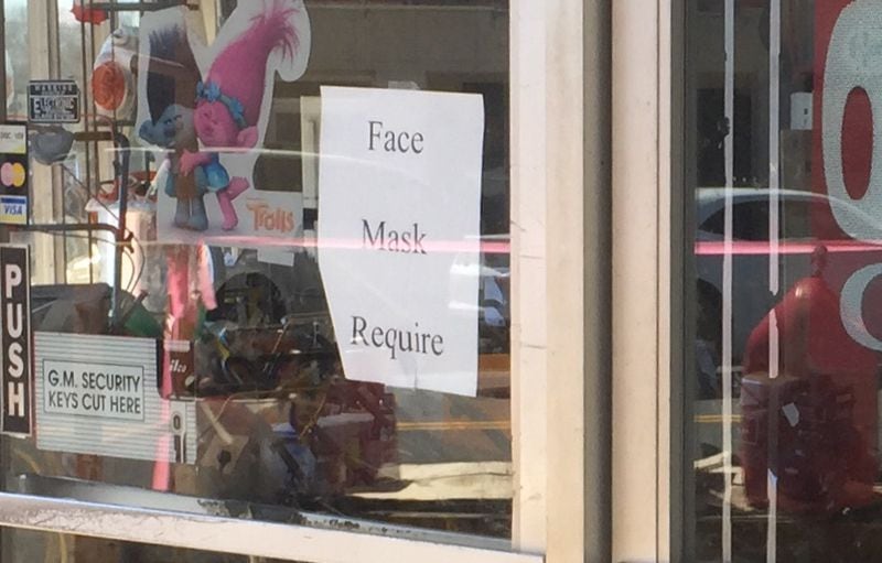 A sign posted in the door of Phillips True Value and Rental Center hardware store in Dawson, Ga., says masks are required. Yet neither the store owner nor an employee had on masks early last week. (Johnny Edwards / Johnny.Edwards@ajc.com)