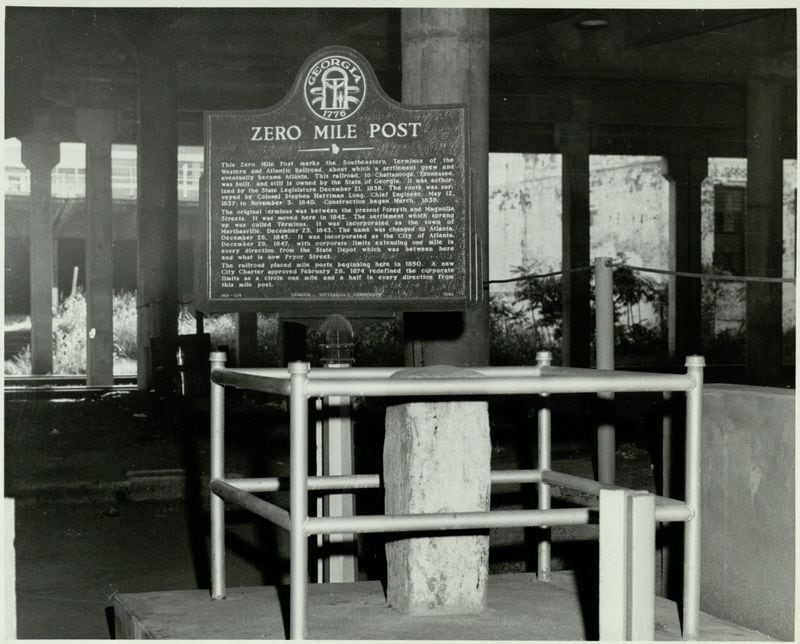 The Zero Mile Post is shown with a brand new historic marker in this photo from 1958. The landmark used to be exposed beneath a downtown viaduct and was open to the public. Today, it sits inslide a government building that remains locked. (AJC Archive at GSU Library / AJCP142-020I)