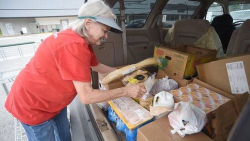 Volunteer Teresa Cate of Chattanooga places food in the back of a client's vehicle at the Chattanooga Area Food Bank Foxwood Plaza emergency food box distribution site on Tuesday, May 24, 2022. (Courtesy of Matt Hamilton)