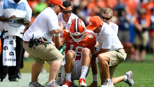 Quarterback Trevor Lawrence #16 of the Clemson Tigers is helped from the field after taking a hard hit from the Syracuse Orange during the football game at Clemson Memorial Stadium on September 29, 2018 in Clemson, South Carolina. (Photo by Mike Comer/Getty Images)