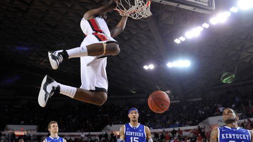 Georgia guard Kentavious Caldwell-Pope (1) hangs from the rim after dunking Thursday against Kentucky in Athens. Georgia won 72-62.