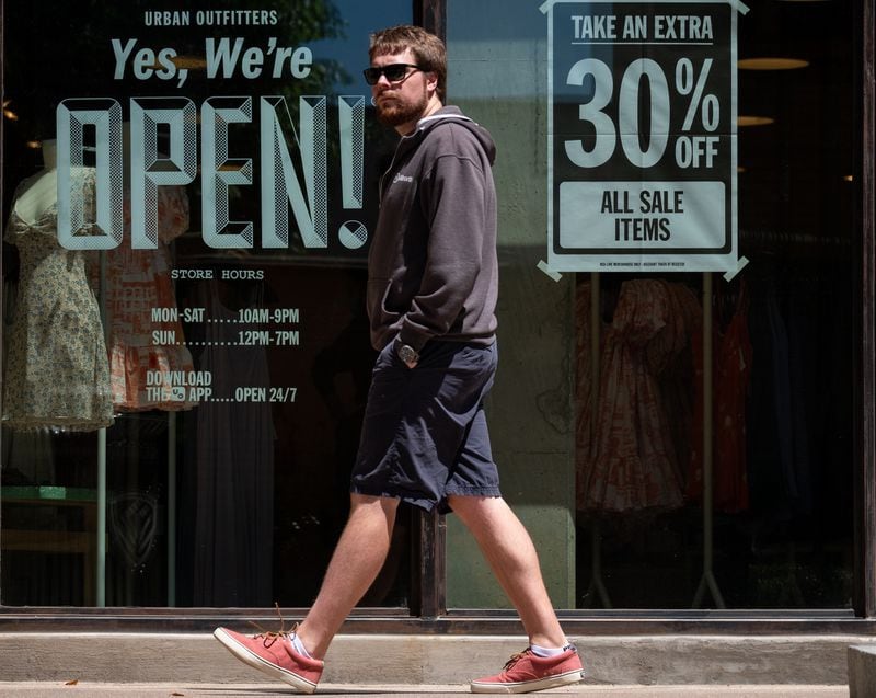 Adam Kryschuk strolls through the Avalon outdoor shopping area in Alpharetta on Friday morning May 1, 2020. Kryschuk, who lives nearby, came with Amy Heigl to walk the dog and see what stores were opening up. (Ben@BenGray.com for the Atlanta Journal-Constitution)