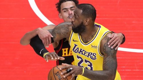 Hawks guard Trae Young fouls Lakers forward LeBron James in the final seconds of a 107-99 loss to the Lakers Monday, Feb.1, 2021, at State Farm Arena in Atlanta.  (Curtis Compton / Curtis.Compton@ajc.com)