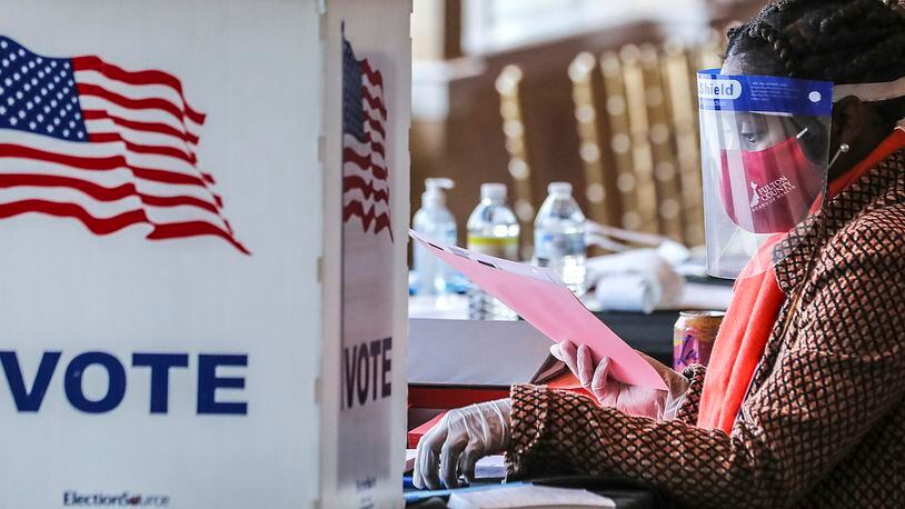Fulton County elections representatives will be in Roswell in September seeking to hire residents as poll workers for Election Day or early voting. Pictured is a poll worker sorting through voting material at Park Tavern in Atlanta in, 2020.  (John Spink / John.Spink@ajc.com)