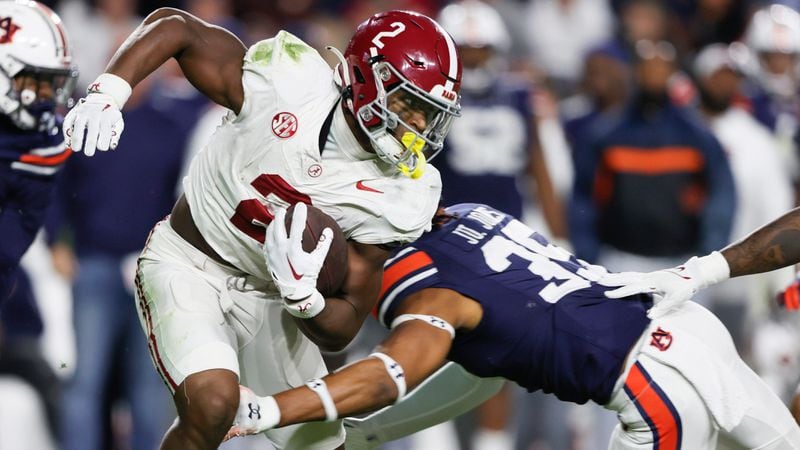 Alabama running back Jase McClellan (2) is tackled by Auburn cornerback Jaylin Simpson (36) as he caries the ball during the second half of an NCAA college football game Saturday, Nov. 25, 2023, in Auburn, Ala. (AP Photo/Butch Dill)