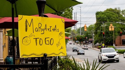 La Hacienda Mexican restaurant on Monroe Drive in Midtown offers margaritas to go Tuesday, April 7, 2020. Signs like these and others will be important to historians one day as they document how Georgians dealt with the pandemic. (Jenni Girtman for the Atlanta Journal Constitution)