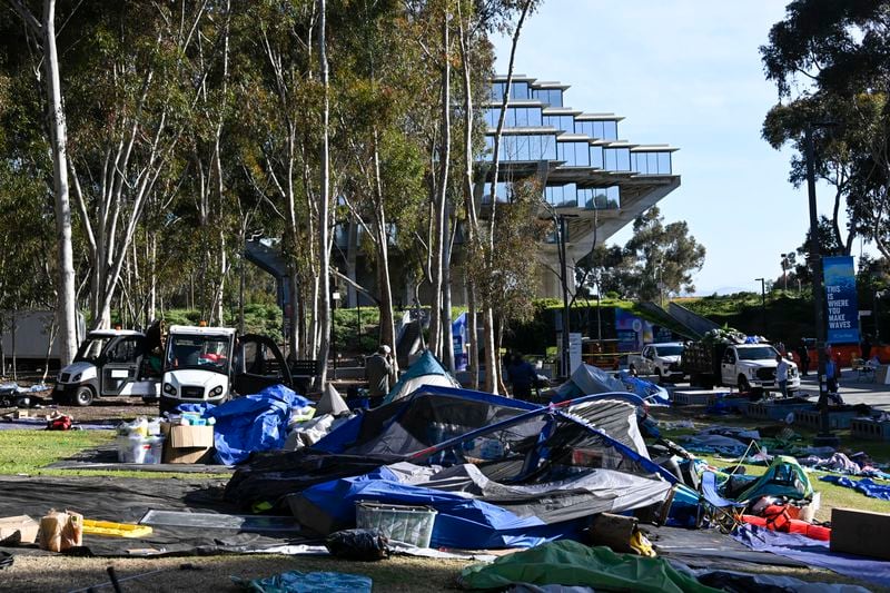 Workers remove tents and debris from a Pro-Palestinian encampment set up in front of Geisel Library at UC San Diego, Monday, May 6, 2024, in San Diego. Police cleared the campus encampment in the early morning Monday. (AP Photo/Denis Poroy)