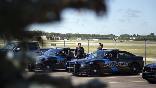 Officers gather at Bishop International Airport, Wednesday, June 21, 2017, in Flint, Mich. Officials evacuated the airport after an officer was stabbed Wednesday.  (Shannon Millard/The Flint Journal-MLive.com via AP)