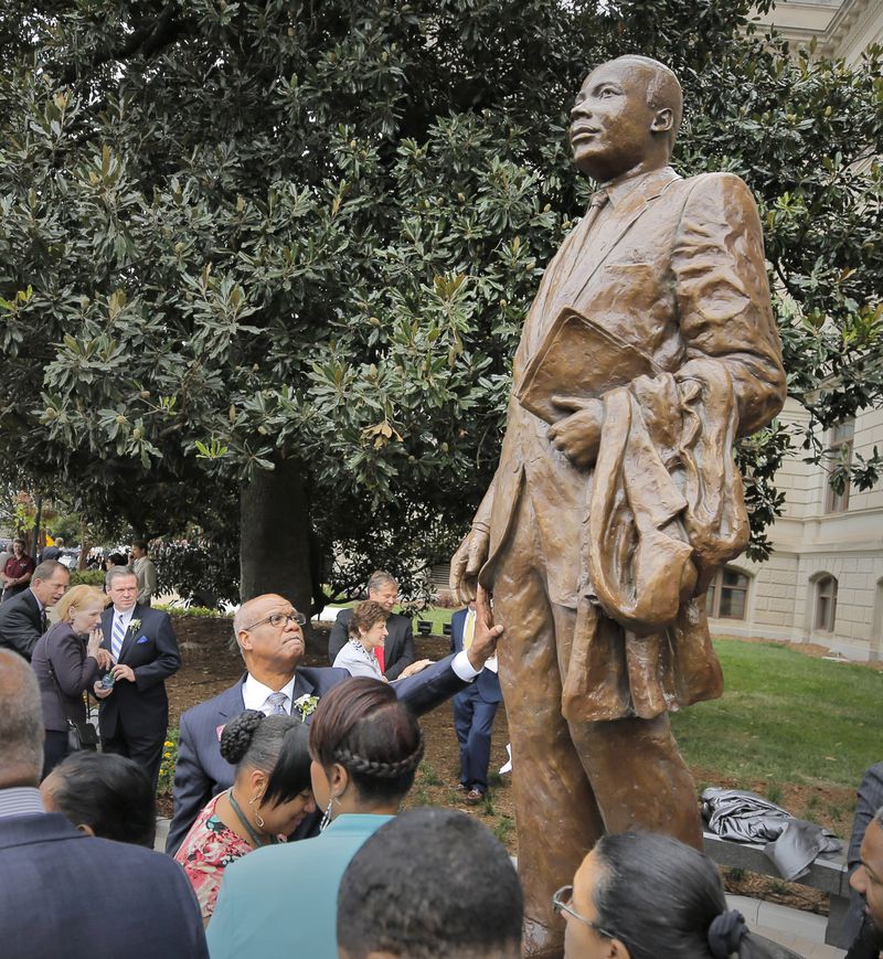 State Rep. Calvin Smyre (hand on statue) played a role in getting the monument to the Rev. Martin Luther King Jr. on the statehouse’s grounds completed. BOB ANDRES /BANDRES@AJC.COM