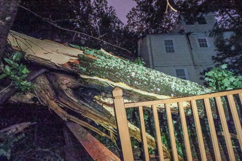 A file photo shows the aftermath after lightning sent parts of a tree crashing into two homes in the North Decatur Road area of DeKalb County. JOHN SPINK / JSPINK@AJC.COM