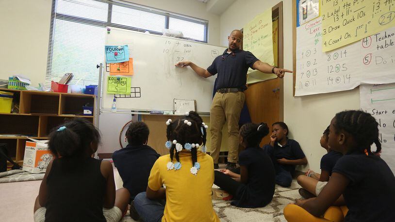 First grade teacher Malcolm Davis teaches his students basic math skills.