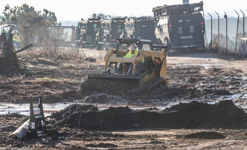 A bulldozer works under the watch of law enforcement at the site of Atlanta's planned public safety training center.