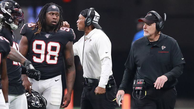 Falcons defensive end Takk McKinley looks to head coach Dan Quinn for direction during a time out Sunday, Sept. 29, 2019, against the Tennessee Titans at Mercedes-Benz Stadium in Atlanta.