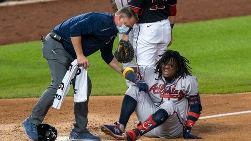 The Braves' Ronald Acuna grimaces as he is helped after fouling the ball off his left ankle during the fourth inning of a game against the  Nationals in Washington on Friday. (AP photo)