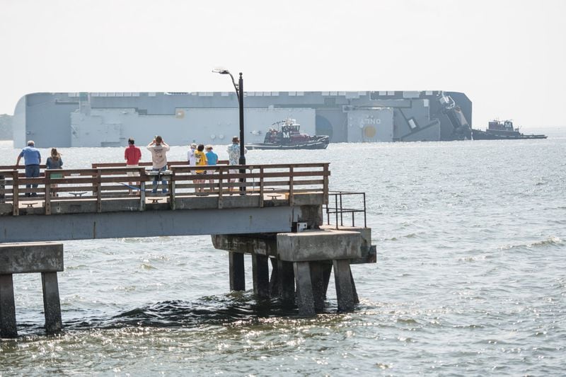People watch from St. Simons Pier as emergency responders work to rescue crew members from a capsized cargo ship on Sept. 9, 2019 in St Simons Island, Georgia. A 656-foot vehicle carrier, the M/V Golden Ray departed the Brunswick port on Sunday and suffered a fire on board, capsizing in St. Simons Sound. PHOTO BY SEAN RAYFORD / GETTY IMAGES