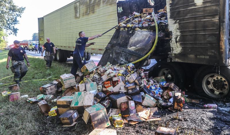 Atlanta fire crews had to remove boxes of dog food from a burning tractor-trailer on the side of I-285 South near Langford Parkway on Wednesday morning in order to fully extinguish the fire. 