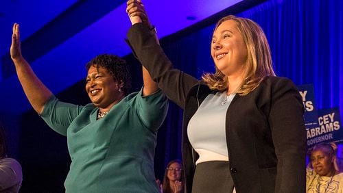 Gubernatorial candidate Stacey Abrams links hands with Lt. Governor candidate Sarah Riggs Amico during the Georgia Democratic convention earlier this year. AJC file