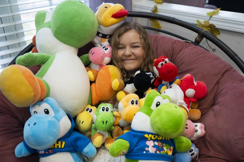 Alaya Horne, age 12, shows off her vast display of Yoshi stuffed animals that she plans to donate to patients at the Children's Hospital on Wednesday, Nov. 22, 2023 in Johns Creek, Georgia. "If I was sick or hurt in the hospital and someone gave me Yoshi, I would be all better," she says when asked why she decided to donate her collection. (Olivia Bowdoin for the Atlanta Journal-Constitution). 