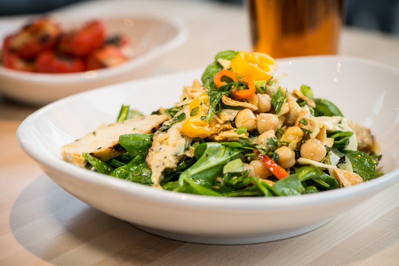 Spice Road Chicken salad with spinach, veggies, herbs, and a golden spice vinaigrette. Photo Credit- Mia Yakel