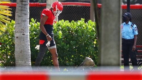A security guard looks on as Georgia wide receiver George Pickens walks to team practice at Barry University on Tuesday, Dec 28, 2021, in Miami Shores.  “Curtis Compton / Curtis.Compton@ajc.com”`