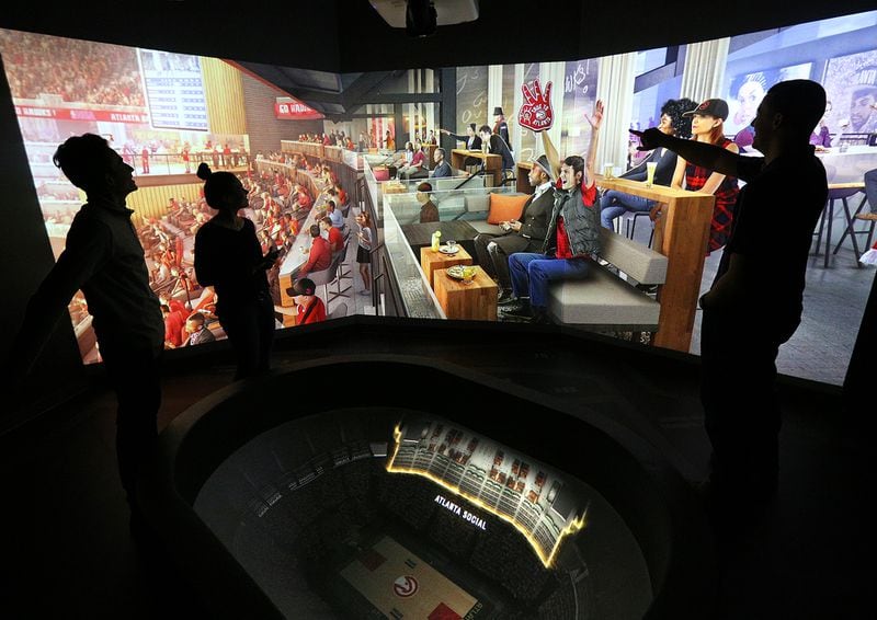  Arpan Patel (from left), Addison Nunes and Aaron Coffey work in “The Pit” area at the Philips Arena preview center, running a projection of the Atlanta Social area, one of the changes coming after the final round of renovation.