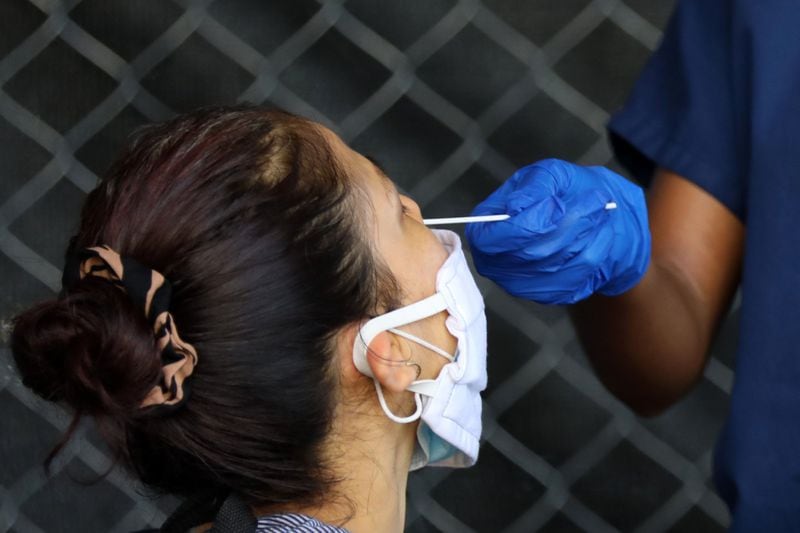A person gets the swab with the COVID-19 test on her nose during a free test drive on the Good Samaritan Clinic’s parking lot. The Clinic offers free check with the results in 15 minutes on June 23, 2020, in Atlanta. 