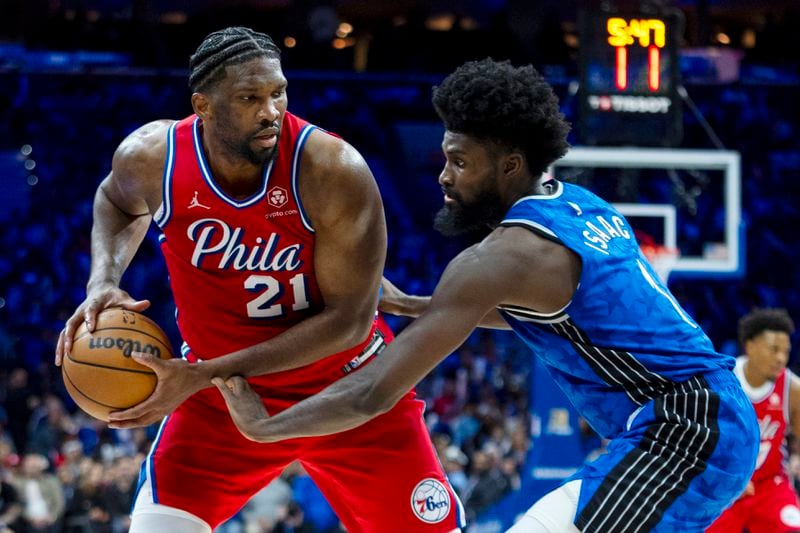 Philadelphia 76ers' Joel Embiid, left, looks to make his move against Orlando Magic's Jonathan Isaac, right, during the second half of an NBA basketball game, Friday, April 12, 2024, in Philadelphia. The 76ers won 125-113. (AP Photo/Chris Szagola)