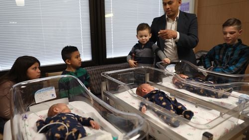 Mario Aguirre and Teri Nobles introduce their triplets, Vincent Alan, front left, Santino Michael, center, and his identical brother Andres Lionel, and their four older siblings, in the back, from left, Brooklynn Aguirre, 11, Mateo Aguirre, 8, twin Marcel Chance Aguirre, 3, and Logan Benson, 10, during an interview at Advocate Good Samaritan Hospital Friday March 30, 2018 in Downer’s Grove, Ill. Contributed byAbel Uribe/Chicago Tribune/TNS
