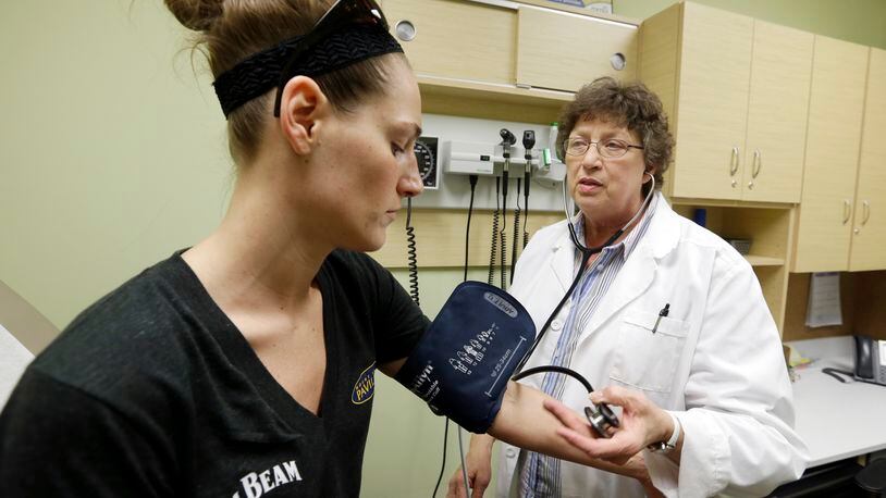 FILE - In this April 3, 2013 file photo, family Nurse Practitioner Ruth Wiley examines Elizabeth Knowles at a Walgreens Take Care Clinic in Indianapolis. (AP Photo/Darron Cummings, File)