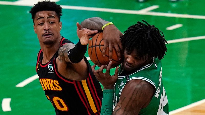 Atlanta Hawks forward John Collins (20) tries to free the ball from the grip of Boston Celtics center Robert Williams III during the second half Wednesday, Feb. 17, 2021, in Boston. (Charles Krupa/AP)