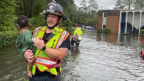 A Valdosta firefighter rescues a small child in a flooded area following Wednesday's storm. (courtesy of Valdosta Fire Department)