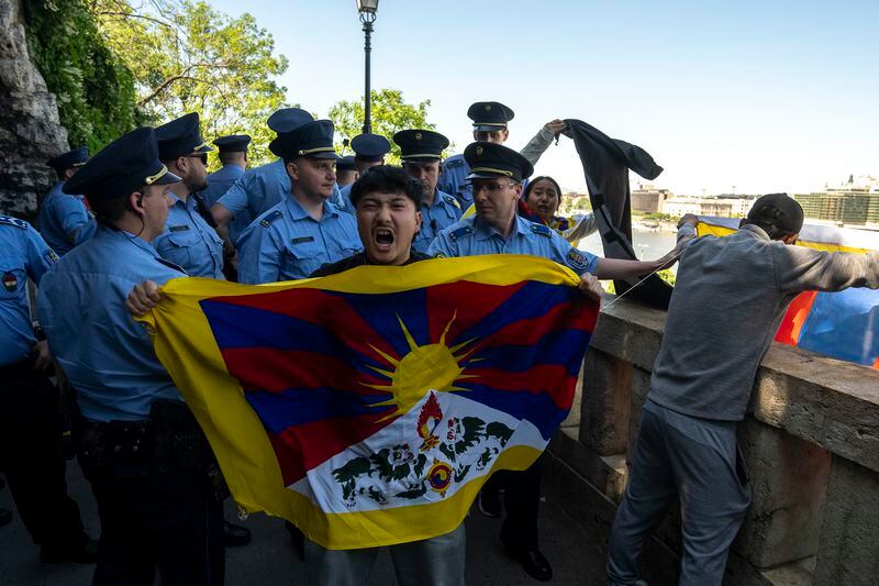 A Tibetan protester shouts surrounded by Hungarian police next to a Tibetan flag in Gellert Hill, against Chinese President Xi Jinping's visit to Budapest, Hungary on Thursday, May 9, 2024. (AP Photo/Denes Erdos)